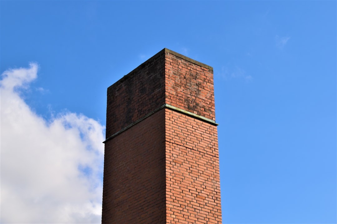 red brick factory chimney in shadow and sunshine perspective 