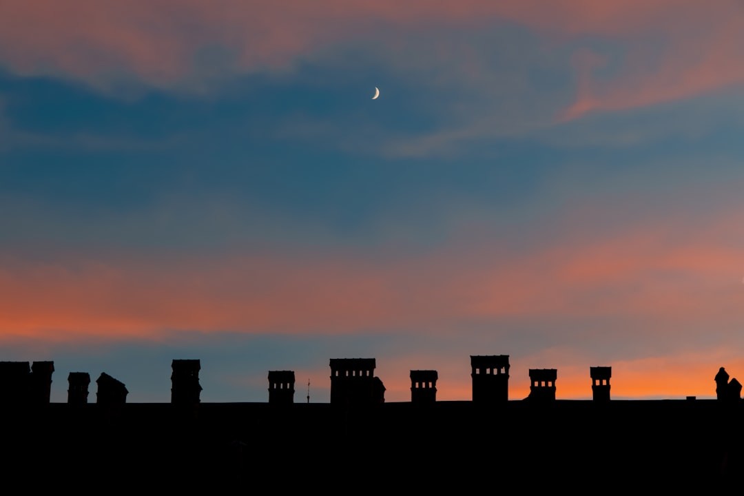 beautiful evening landmark wallpaper building urban view with chimney roof and picturesque sunset sky purple orange and blue color with young moon and empty copy space for your text here